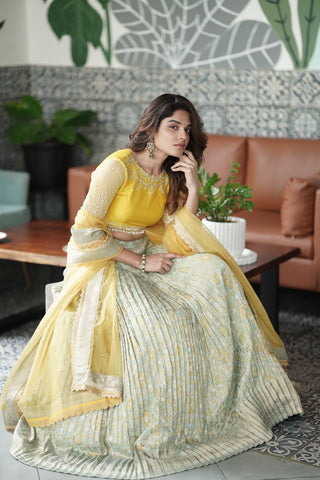 Vibrant Yellow & Pista Bandhani Lehenga from MyRiti, showcasing the traditional art of Bandhani. Ideal for those searching for unique online lehengas, this piece blends cultural heritage with modern elegance.